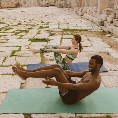 Diverse group of people in various yoga poses, smiling.